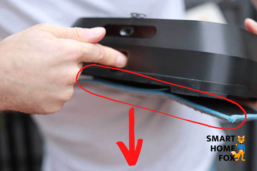 Der Knopf an der Vorderseite des Braava jet m6 wird gedrückt und das Wischpad löst sich